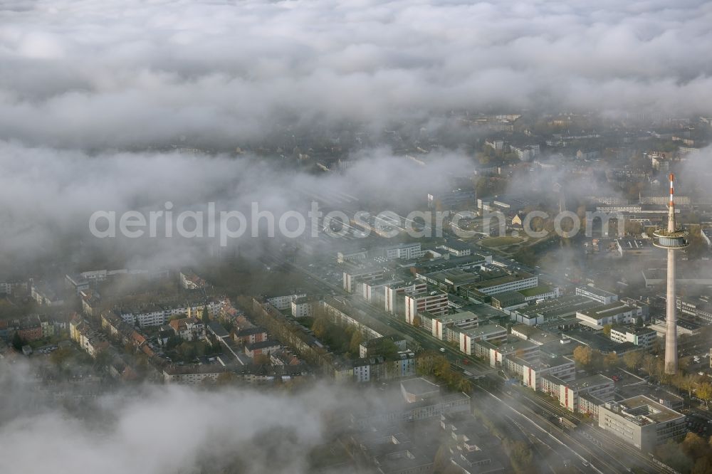 Aerial image Essen - View of the area around the telecommunication tower and ETEC shrouded by fog patches and autumn weather clouds in the state North Rhine-Westphalia. The top of the television tower breaks through an impressive cloud cover over the Holsterhausen district in the Ruhr region city