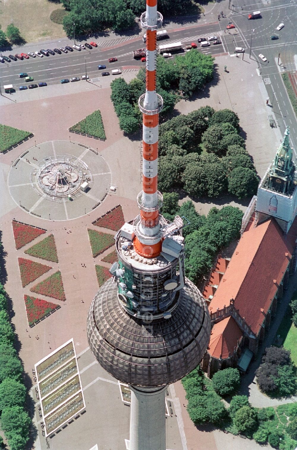 Berlin from above - The TV Tower, St. Mary's Church and Neptune's Fountain are the key attractions at Alexanderplatz in Berlin-Mitte. The TV Tower, one of the landmarks of the capital city is regarded as the tallest building in Germany. In the sphere there is a viewing platform and a restaurant. The St. Mary's Church was built in the Middle Ages in the style of brick gothic. The Fountain of Neptune is a fountain, which was created by the sculptor Reinhold Begas