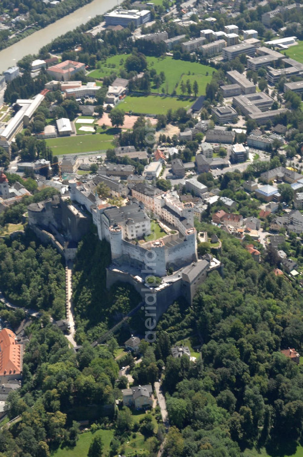 SALZBURG from above - Die 900 Jahre alte Festung Hohensalzburg, das Wahrzeichen der Stadt, ist Europas größte und noch am besten erhaltene Burganlage. Heute gilt sie als Europas größte Festungsanlage mit mehr als 14.000 m² Baufläche. Salzburg 2007/07/14 Festung Hohensalzburg is a castle in the Austrian city of Salzburg. It sits on Festungberg hill. With a length of 250 meters and a width of 150 meters, it is one of the largest medieval castles in Europe.