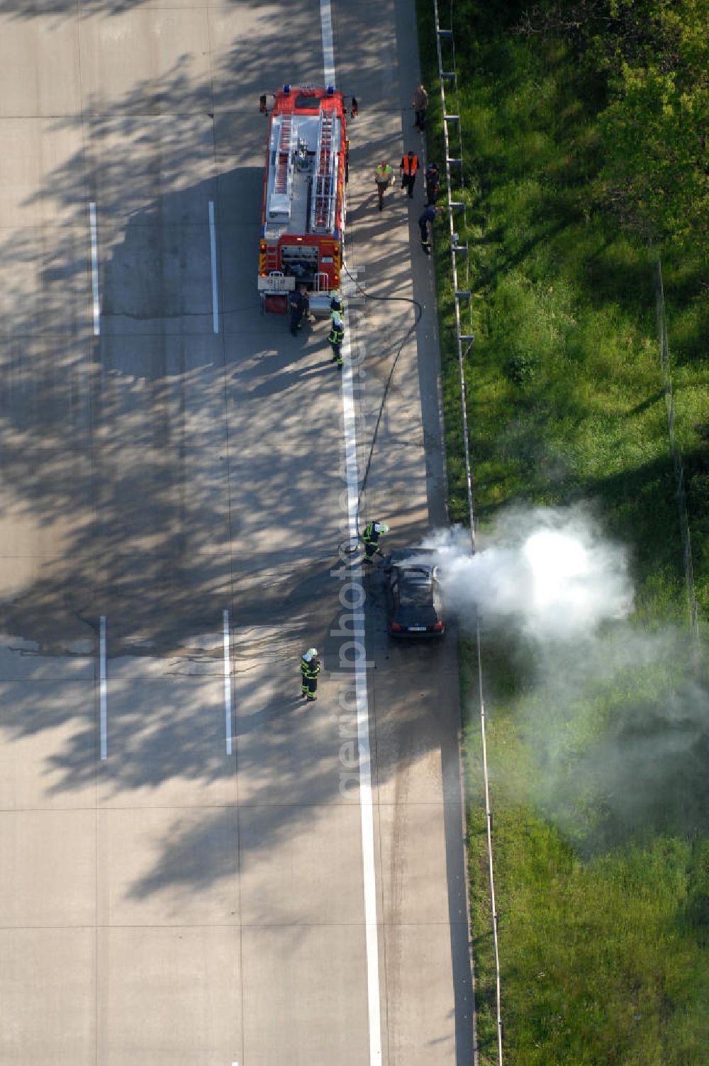 Dessau from the bird's eye view: Blick auf einen Feuerwehreinsatz zur Löschung eines PKW- Brandes auf der Autobahn A9 / E51 bei Dessau. View of a fire department for cancellation of a car fire on the highway A9 / E51 in Dessau.