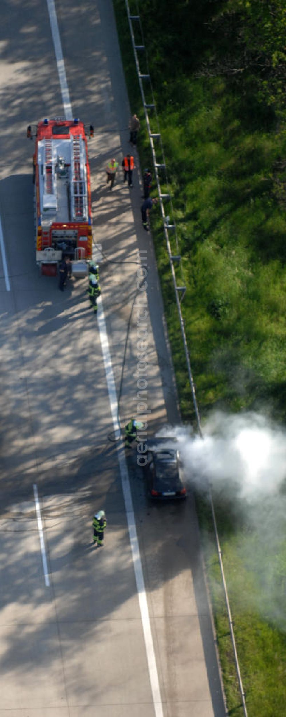 Aerial photograph Dessau - Blick auf einen Feuerwehreinsatz zur Löschung eines PKW- Brandes auf der Autobahn A9 / E51 bei Dessau. View of a fire department for cancellation of a car fire on the highway A9 / E51 in Dessau.