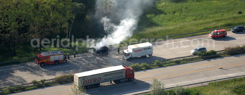 Aerial photograph Dessau - Blick auf einen Feuerwehreinsatz zur Löschung eines PKW- Brandes auf der Autobahn A9 / E51 bei Dessau. View of a fire department for cancellation of a car fire on the highway A9 / E51 in Dessau.