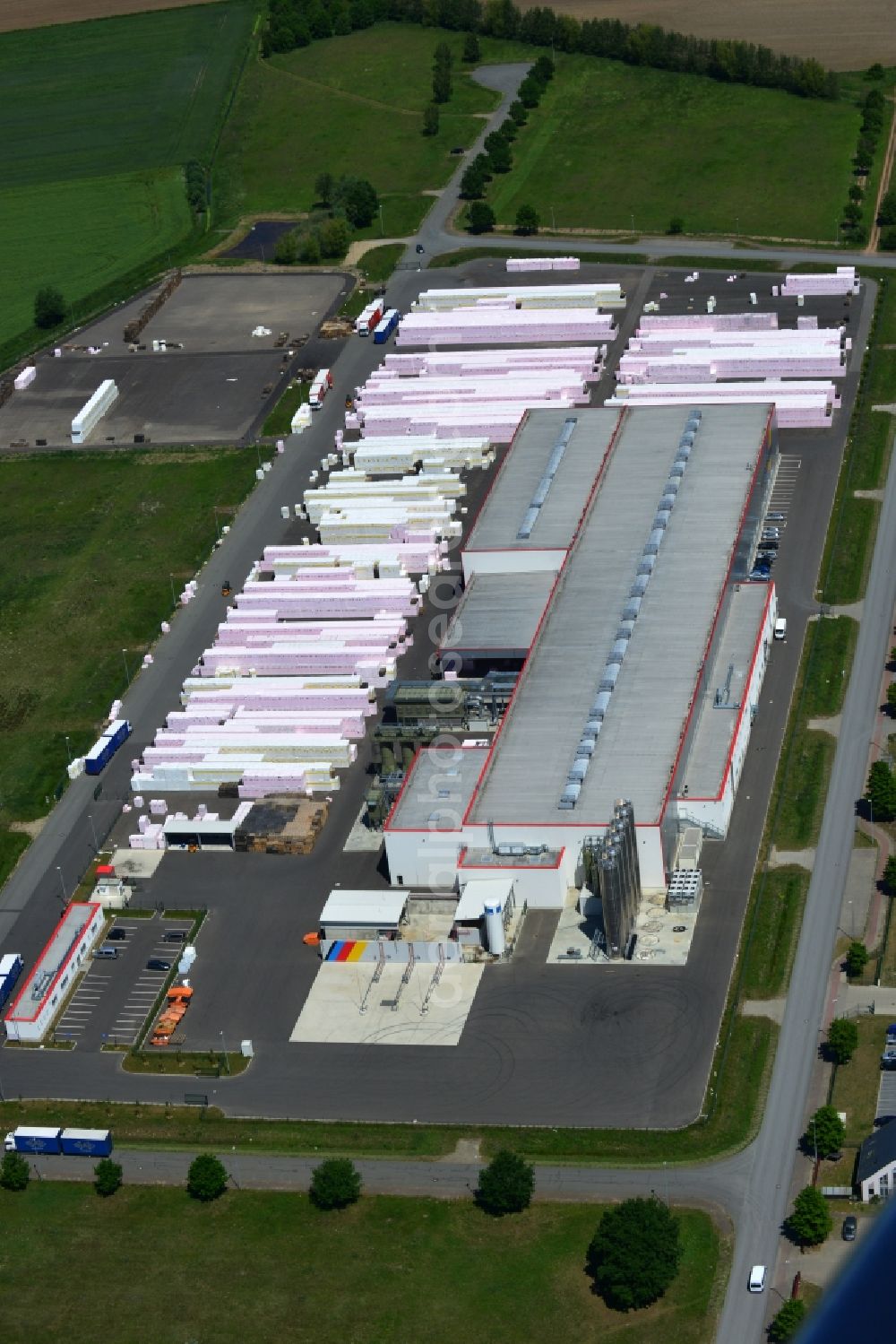 Wittenberge from above - Company building and production site of Austrotherm company in the Northwest of Wittenberg in the state of Brandenburg. Austrotherm produces insulating material on site in the industrial area of Wittenberg. View of the company building and material on the compound