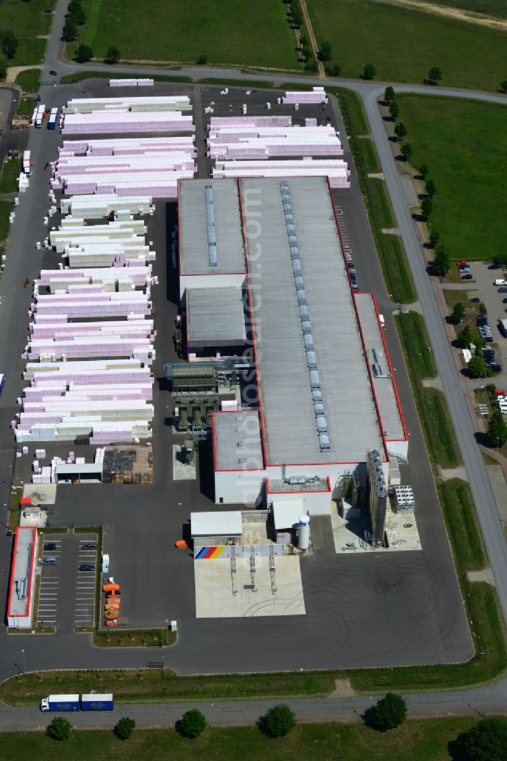 Wittenberge from the bird's eye view: Company building and production site of Austrotherm company in the Northwest of Wittenberg in the state of Brandenburg. Austrotherm produces insulating material on site in the industrial area of Wittenberg. View of the company building and material on the compound