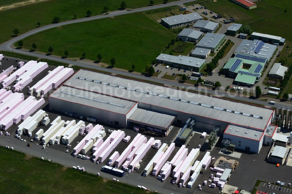 Aerial photograph Wittenberge - Company building and production site of Austrotherm company in the Northwest of Wittenberg in the state of Brandenburg. Austrotherm produces insulating material on site in the industrial area of Wittenberg. View of the company building and material on the compound