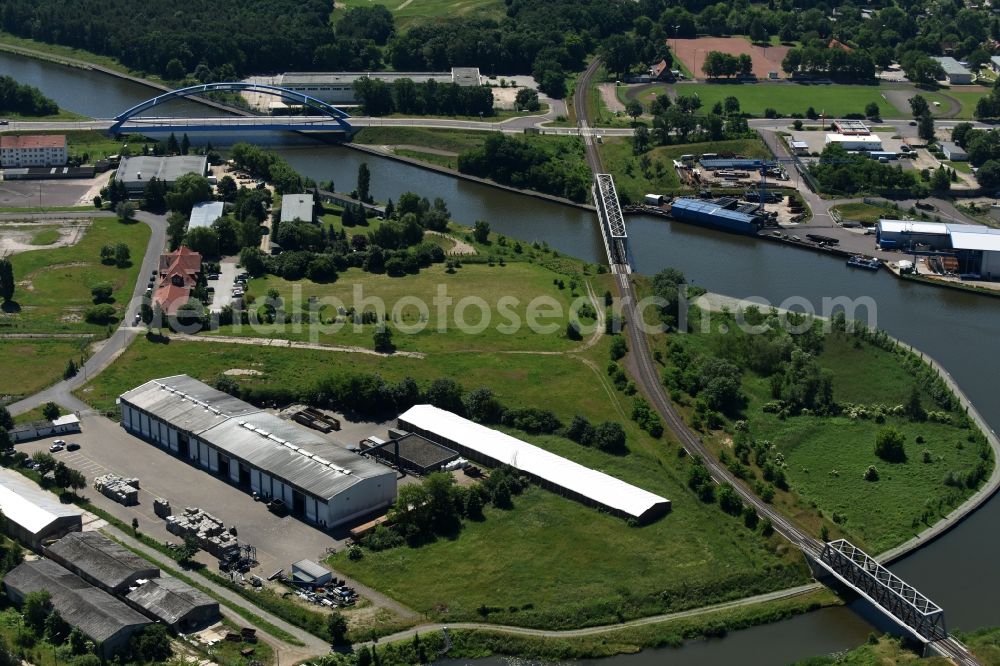 Aerial image Genthin - Company grounds and facilities of the recycling company Cabka GmbH on the riverbank of the Elbe-Havel-Canal in Genthin in the state of Saxony-Anhalt. A blue steel bridge and a railway bridge are located in the background