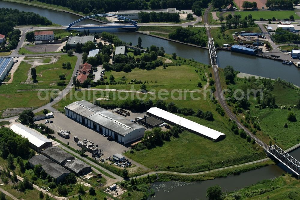 Aerial photograph Genthin - Company grounds and facilities of the recycling company Cabka GmbH on the riverbank of the Elbe-Havel-Canal in Genthin in the state of Saxony-Anhalt. A blue steel bridge and a railway bridge are located in the background