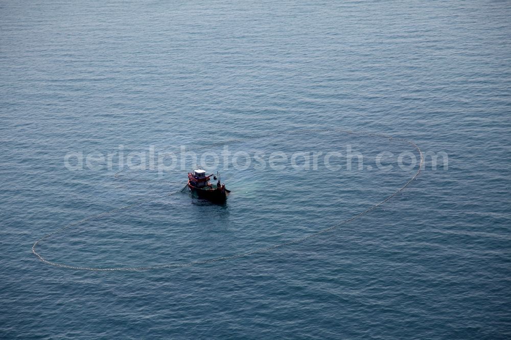 Ratsada from the bird's eye view: Fishing boat at hauling a net on the coast of the peninsula of Laem Tukkae at Ratsada on the island of Phuket in Thailand