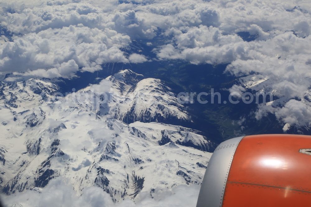 Meiringen from above - Flight with the airliner over the Alps in Meiringen in Switzerland. Cumulus clouds above the snowy mountain Peaks