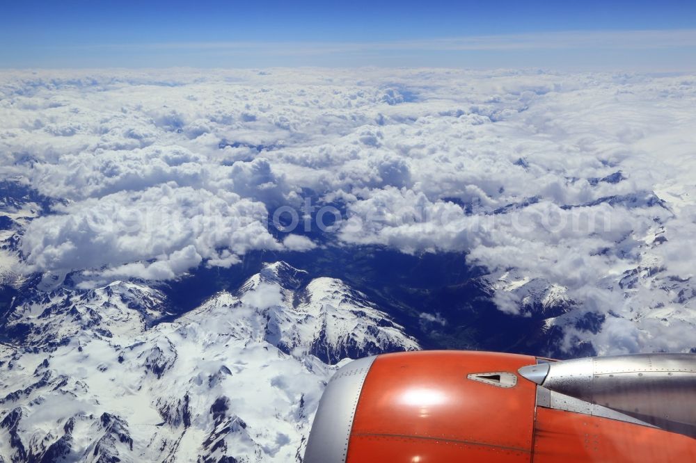 Meiringen from the bird's eye view: Flight with the airliner over the Alps in Meiringen in Switzerland. Cumulus clouds above the snowy mountain Peaks