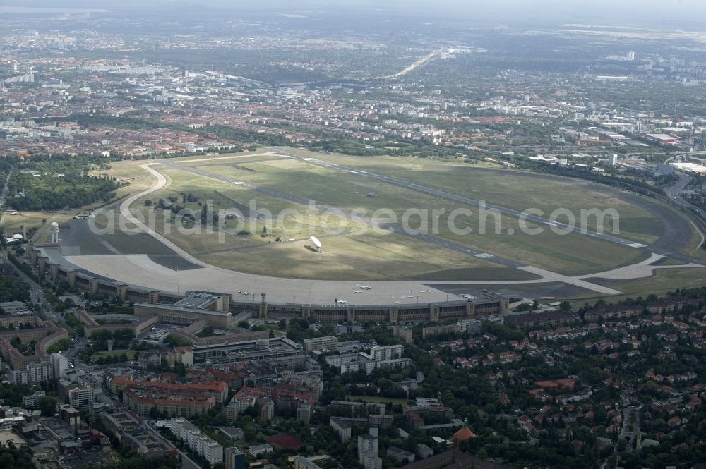 Berlin from above - Air traffic at the airport Tempelhof in Berlin. Bevor the hangars and terminals standing various planes at the runaway and apron