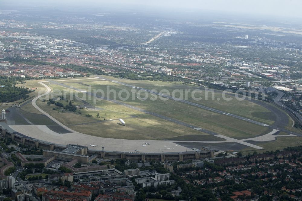 Berlin from the bird's eye view: Air traffic at the airport Tempelhof in Berlin. Bevor the hangars and terminals standing various planes at the runaway and apron