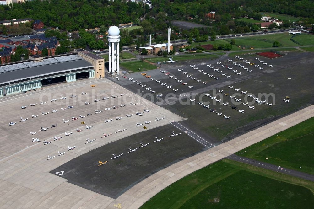 Berlin from the bird's eye view: Air traffic at the airport Tempelhof in Berlin. Bevor the hangars and terminals standing various planes at the runaway and apron