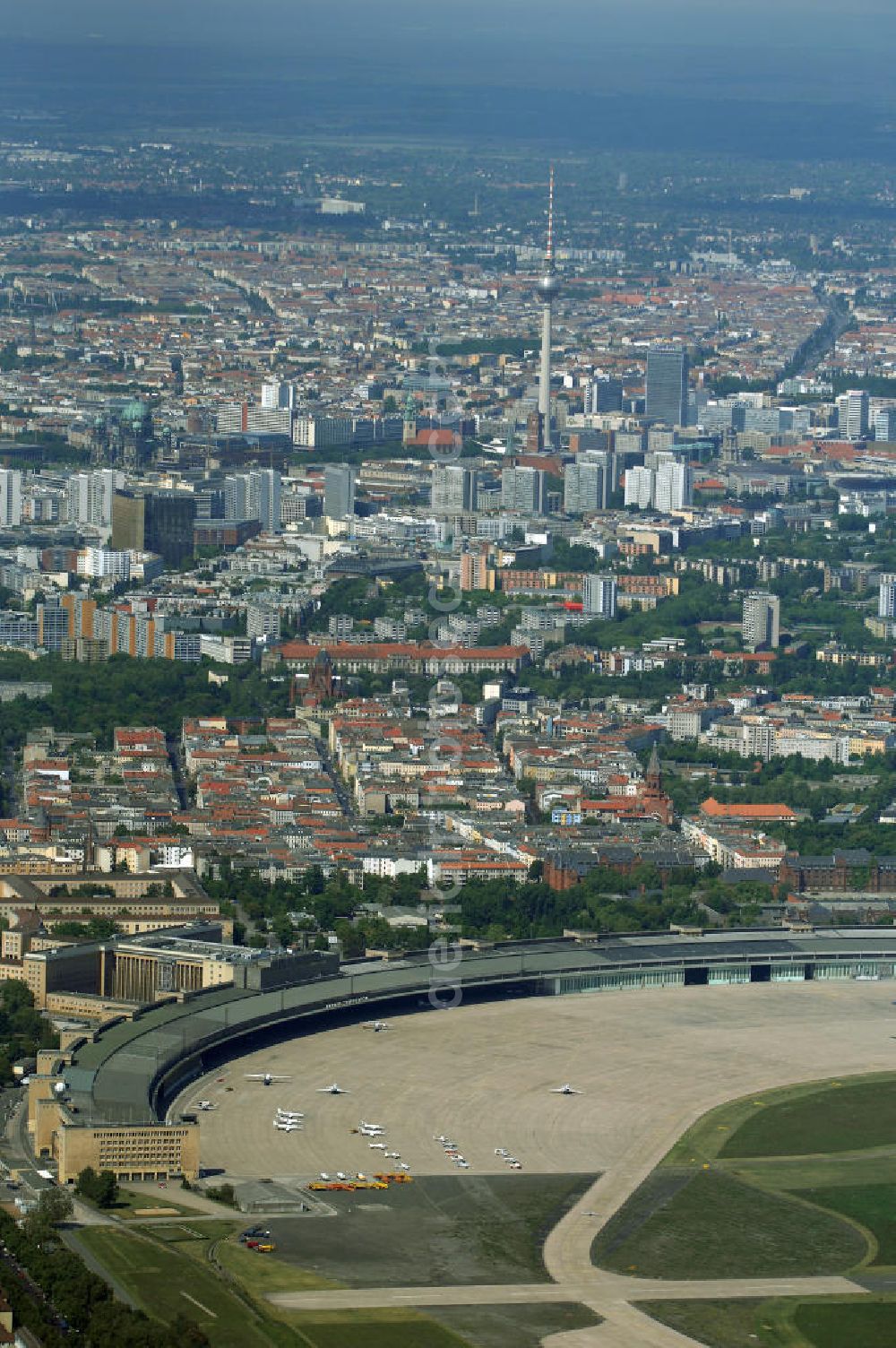 Aerial image Berlin - Der Flughafen Berlin-Tempelhof (IATA-Code: THF, ICAO-Code: EDDI) ist der älteste und kleinste der drei derzeit noch in Betrieb befindlichen Verkehrsflughäfen im Großraum Berlin. Um die Schließung des Flughafens doch noch zu verhindern, wurde von der Interessengemeinschaft City-Airport Tempelhof e.V. ein Volksentscheid angestrebt. Dazu wurden zunächst seit Ende November 2006 Unterschriften für die Unterstützung eines Volksbegehrens gesammelt. Am 8. Mai 2007 bestätigte der Berliner Senat die Sammlung von knapp 30.000 gültigen Unterschriften. Damit wurde der nach der Verfassung von Berlin erforderliche Nachweis von mindestens 20.000 Unterstützern für die Einleitung eines Volksbegehrens erbracht. Der nun abzuhaltende Volksentscheid wird am 27. April 2008 stattfinden. Das Ergebnis dieses Volksentscheides ist rechtlich jedoch nicht bindend, da das Volksbegehren keinen konkreten Gesetzentwurf zum Gegenstand hat, sondern lediglich eine Stimmung ausdrücken soll. Die Kosten für die Durchführung des Volksentscheides betragen etwa 2,5 Millionen Euro.[14] Auf politischer Seite setzen sich CDU und FDP für eine Ausweitung des Flugbetriebes ein; SPD, Bündnis 90-Die Grünen und Die Linke werben für ein Ende des Flugbetriebes. Ursprünglich war die Schließungs vom Berliner Senat unter einer CDU/SPD-Koalition beschlossen worden.