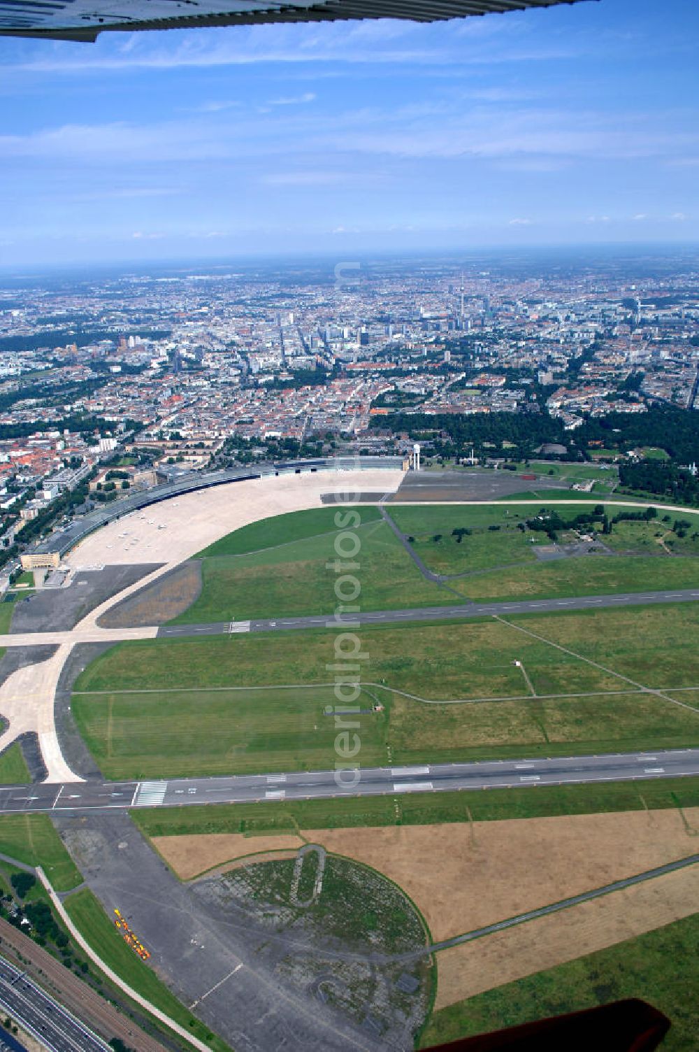 Aerial image Berlin - Blick auf das Areal des historischen Flughafens Berlin-Tempelhof. Die Klage der Fluggesellschaften gegen den neuen Schließungsbescheid vom August 2006, der das Ende der Flugbetriebes für Oktober 2007 vorsah, wurde am 19. und 21. Dezember 2006 vor dem OVG in Berlin verhandelt. Ein vom OVG vorgeschlagener Vergleich zur Anerkennung eines auf Oktober 2008 neu datierten Schließungsbescheides scheiterte an der fehlenden Zustimmung der meisten klagenden Luftfahrtunternehmen. Der Berliner Senat griff den Vergleich des OVG auf und änderte nochmals den Bescheid zum Widerruf der Betriebserlaubnis für den Flughafen Tempelhof, der nun als Datum für die Schließung den 31. Oktober 2008 vorsieht.Am 12. Februar 2007 bestätigte das Oberverwaltungsgericht Berlin-Brandenburg die Rechtmäßigkeit des Schließungsbescheides des Berliner Senats