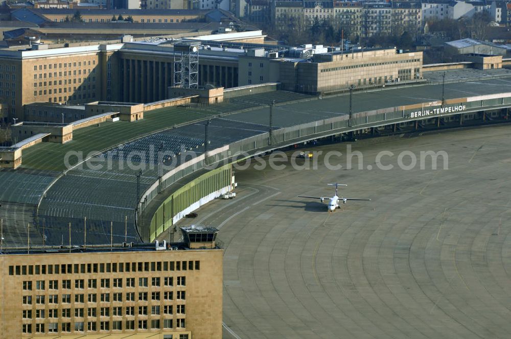 Aerial photograph Berlin - Blick auf das Areal des historischen Flughafens Berlin-Tempelhof. Die Klage der Fluggesellschaften gegen den neuen Schließungsbescheid vom August 2006, der das Ende der Flugbetriebes für Oktober 2007 vorsah, wurde am 19. und 21. Dezember 2006 vor dem OVG in Berlin verhandelt. Ein vom OVG vorgeschlagener Vergleich zur Anerkennung eines auf Oktober 2008 neu datierten Schließungsbescheides scheiterte an der fehlenden Zustimmung der meisten klagenden Luftfahrtunternehmen. Der Berliner Senat griff den Vergleich des OVG auf und änderte nochmals den Bescheid zum Widerruf der Betriebserlaubnis für den Flughafen Tempelhof, der nun als Datum für die Schließung den 31. Oktober 2008 vorsieht.Am 12. Februar 2007 bestätigte das Oberverwaltungsgericht Berlin-Brandenburg die Rechtmäßigkeit des Schließungsbescheides des Berliner Senats