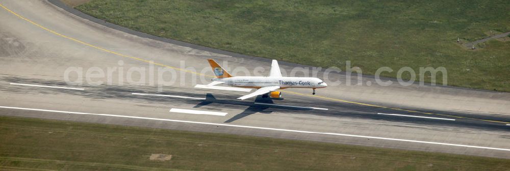 Aerial photograph Düsseldorf - Blick auf die Landebahn des Flughafen Düsseldorf mit landendem Ferienflieger der Gesellschaft Thomas Cook.