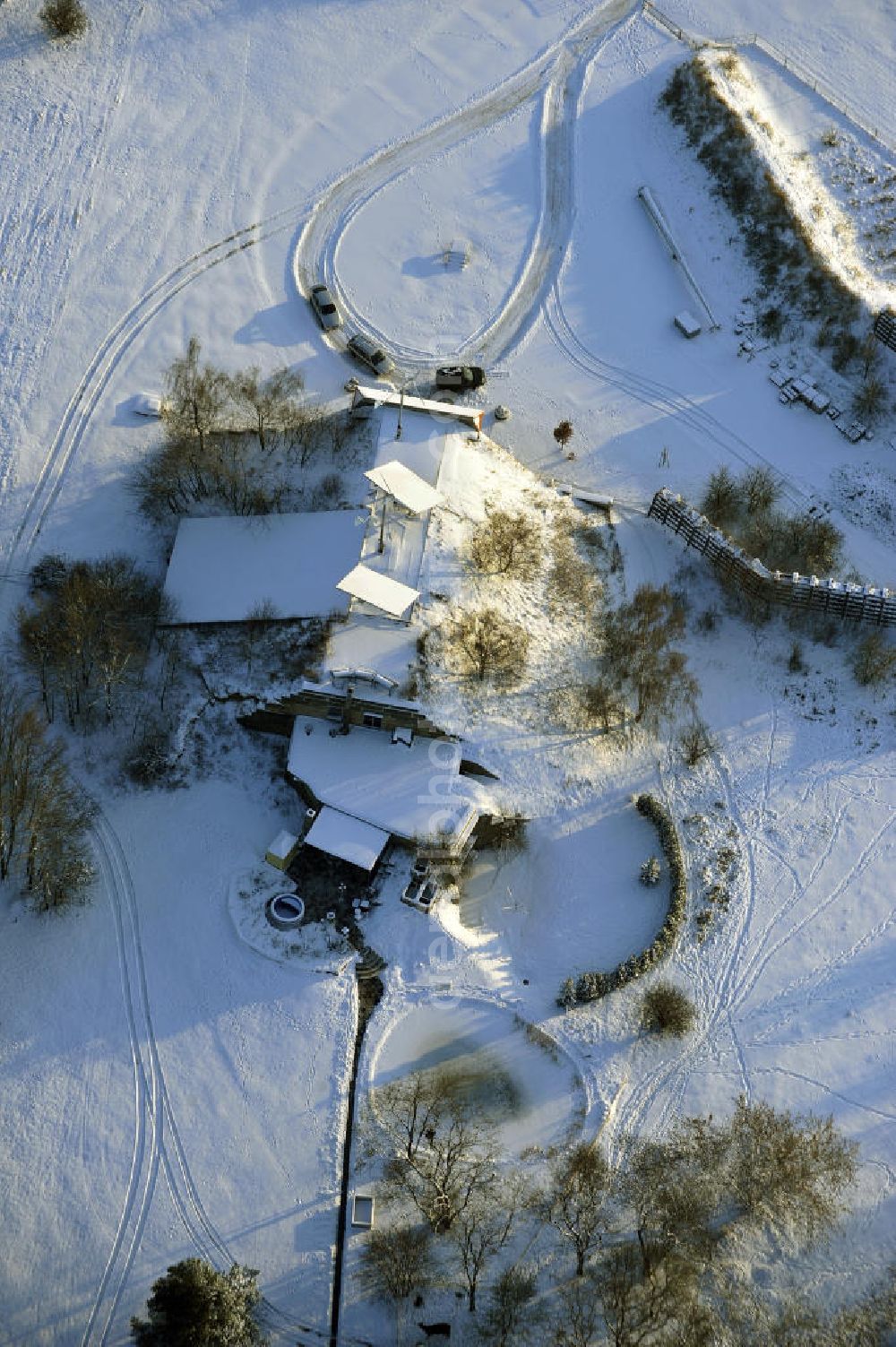 Werneuchen from the bird's eye view: Zivile Nutzung / Konversion der alten Shelter / Flugzeughallen des winterlich, mit Schnee bedeckten Flugplatzes Werneuchen. Der Flugplatz diente seit den 1930er Jahren als Fliegerhorst und wurde danach von der Sowjetarmee als Flugplatz für Jagdbomber genutzt. Civilian use of the facilities of the winterly with snow-covered airfield Werneuchen.