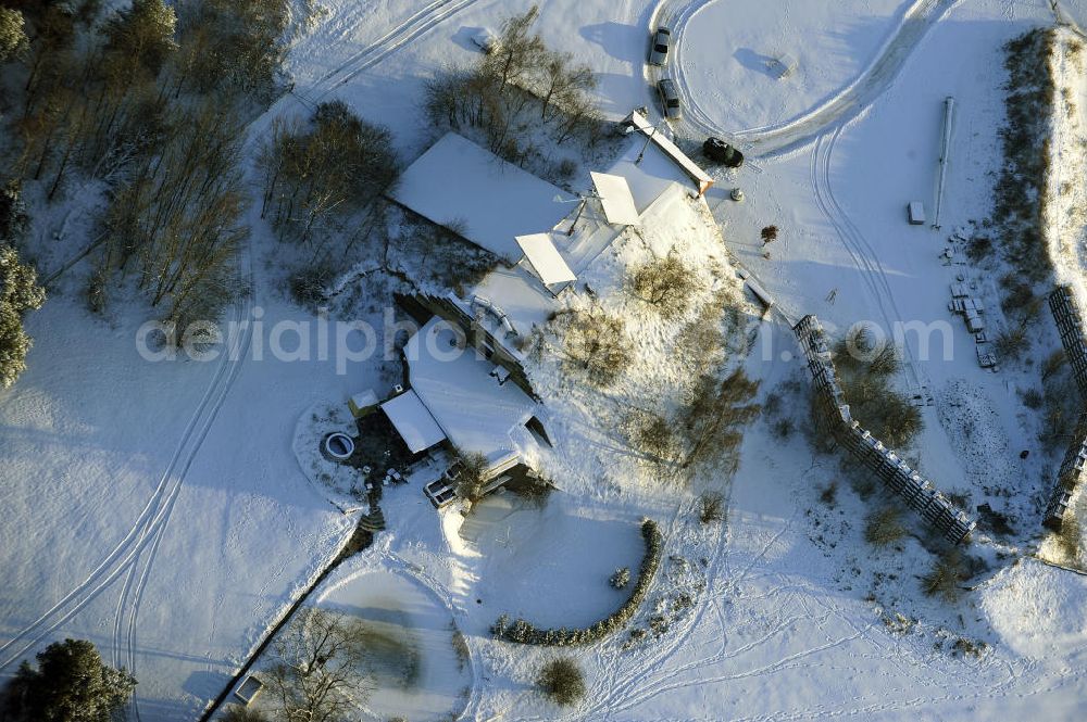 Aerial photograph Werneuchen - Zivile Nutzung / Konversion der alten Shelter / Flugzeughallen des winterlich, mit Schnee bedeckten Flugplatzes Werneuchen. Der Flugplatz diente seit den 1930er Jahren als Fliegerhorst und wurde danach von der Sowjetarmee als Flugplatz für Jagdbomber genutzt. Civilian use of the facilities of the winterly with snow-covered airfield Werneuchen.