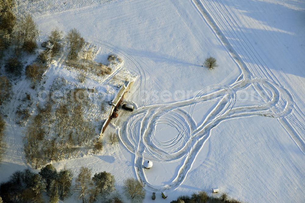 Werneuchen from the bird's eye view: Zivile Nutzung / Konversion der alten Shelter / Flugzeughallen des winterlich, mit Schnee bedeckten Flugplatzes Werneuchen. Der Flugplatz diente seit den 1930er Jahren als Fliegerhorst und wurde danach von der Sowjetarmee als Flugplatz für Jagdbomber genutzt. Civilian use of the facilities of the winterly with snow-covered airfield Werneuchen.