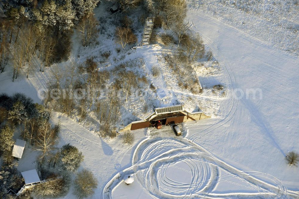 Aerial image Werneuchen - Zivile Nutzung / Konversion der alten Shelter / Flugzeughallen des winterlich, mit Schnee bedeckten Flugplatzes Werneuchen. Der Flugplatz diente seit den 1930er Jahren als Fliegerhorst und wurde danach von der Sowjetarmee als Flugplatz für Jagdbomber genutzt. Civilian use of the facilities of the winterly with snow-covered airfield Werneuchen.