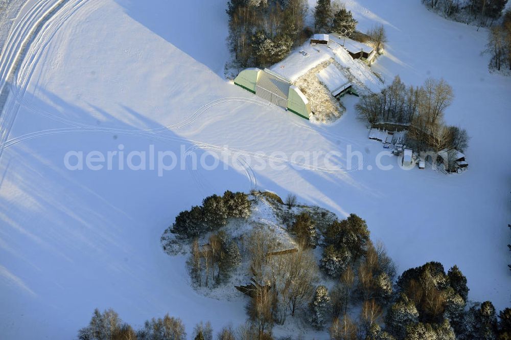 Werneuchen from above - Zivile Nutzung / Konversion der alten Shelter / Flugzeughallen des winterlich, mit Schnee bedeckten Flugplatzes Werneuchen. Der Flugplatz diente seit den 1930er Jahren als Fliegerhorst und wurde danach von der Sowjetarmee als Flugplatz für Jagdbomber genutzt. Civilian use of the facilities of the winterly with snow-covered airfield Werneuchen.