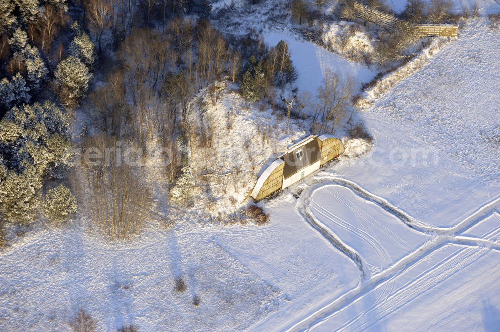 Werneuchen from the bird's eye view: Zivile Nutzung / Konversion der alten Shelter / Flugzeughallen des winterlich, mit Schnee bedeckten Flugplatzes Werneuchen. Der Flugplatz diente seit den 1930er Jahren als Fliegerhorst und wurde danach von der Sowjetarmee als Flugplatz für Jagdbomber genutzt. Civilian use of the facilities of the winterly with snow-covered airfield Werneuchen.