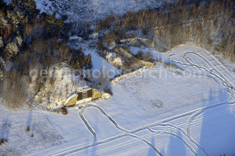 Aerial image Werneuchen - Zivile Nutzung / Konversion der alten Shelter / Flugzeughallen des winterlich, mit Schnee bedeckten Flugplatzes Werneuchen. Der Flugplatz diente seit den 1930er Jahren als Fliegerhorst und wurde danach von der Sowjetarmee als Flugplatz für Jagdbomber genutzt. Civilian use of the facilities of the winterly with snow-covered airfield Werneuchen.