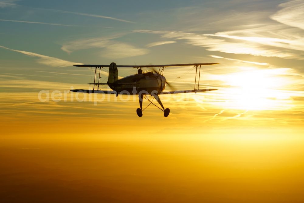 Aerial image Kranenburg - Aircraft Buecker 131 in flight over the airspace in Kranenburg in the state of Lower Saxony, Germany. The Buecker Bue 131 Jungmann was the first aircraft of the aircraft manufacturer Buecker Flugzeugbau