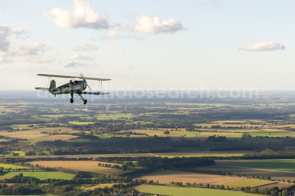 Fredenbeck from the bird's eye view: Historical aircraft and bi-plane Buecker 131 Jungmann in flight over the airspace in Bremervoerde in the state Lower Saxony, Germany