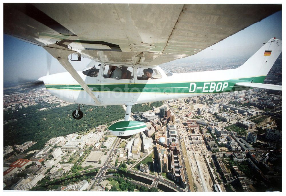 Berlin from the bird's eye view: Cessna 172 with the identifier D-EBOB Aircraft in flight over the airspace on place Potsdamer Platz in the district Tiergarten in Berlin, Germany