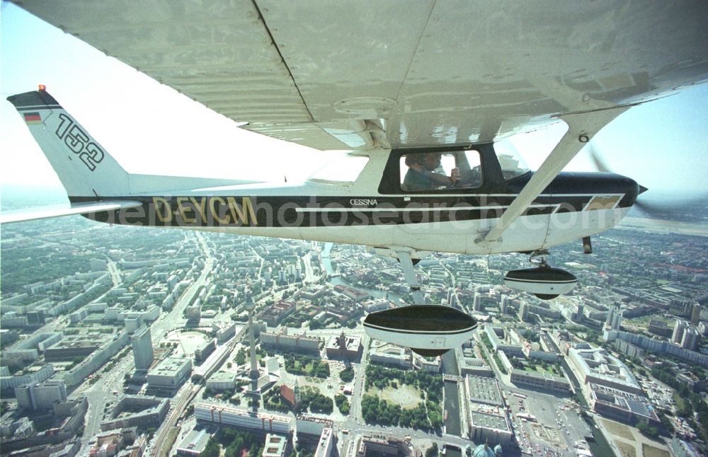 Berlin from the bird's eye view: Cessna 152 with the identifier D-EYCM Aircraft in flight over the airspace on place Alexanderplatz in the district Mitte in Berlin, Germany