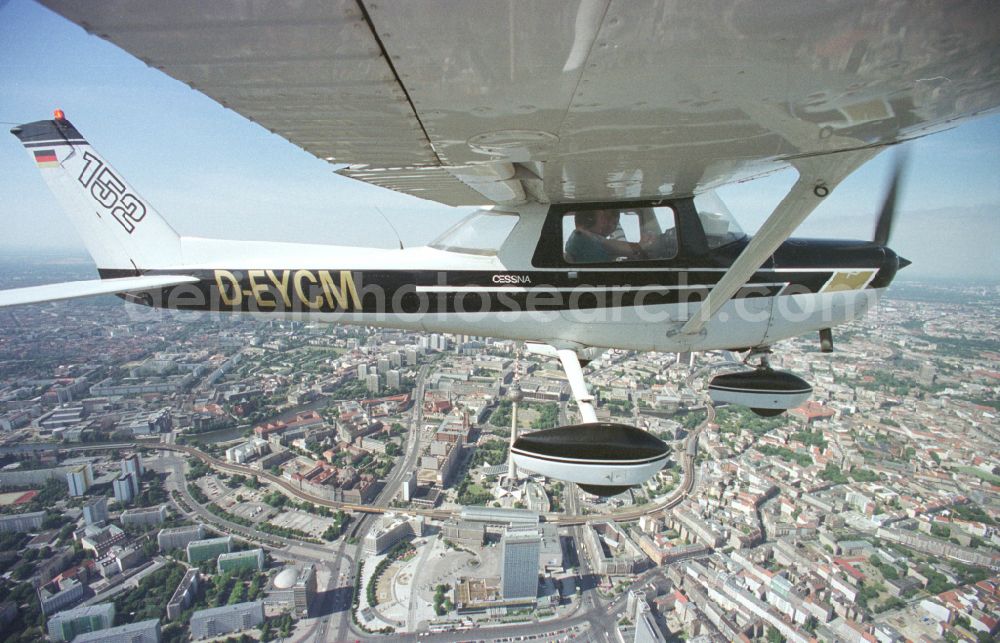 Berlin from the bird's eye view: Cessna 152 with the identifier D-EYCM Aircraft in flight over the airspace on place Alexanderplatz in the district Mitte in Berlin, Germany