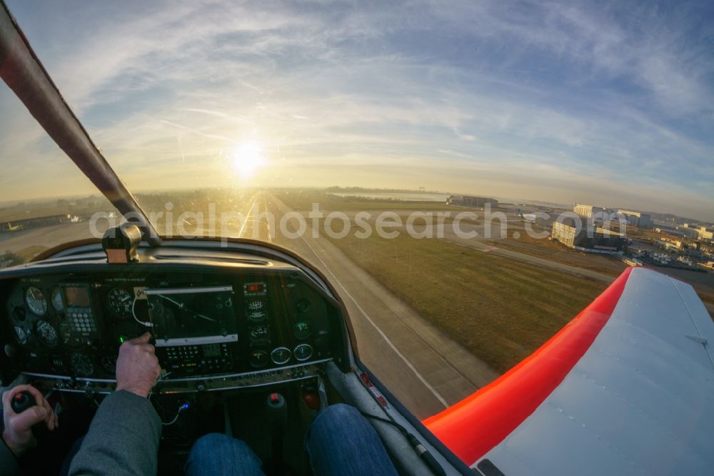 Hamburg from the bird's eye view: Airplane DR-400 D-EBSF in flight at the Hamburg-Finkenwerder airport in Hamburg, Germany. A special landing site and part of the plant site of Airbus Operations GmbH in Hamburg-Finkenwerder