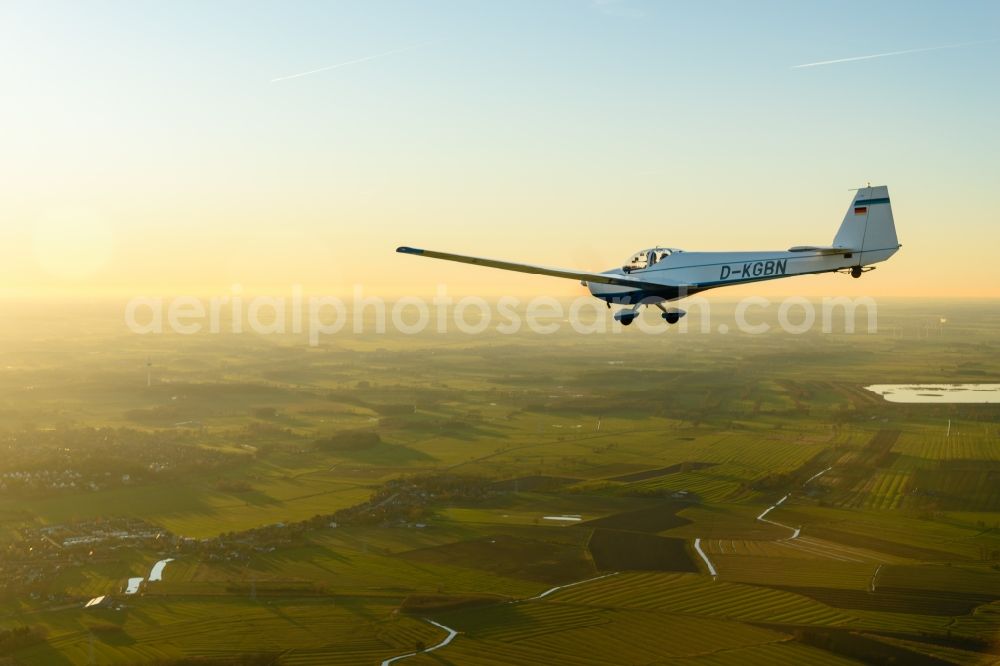 Aerial photograph Stade - And Motorsegler SF 25 Aircraft in flight while sunset over the airspace in Stade in the state Lower Saxony, Germany