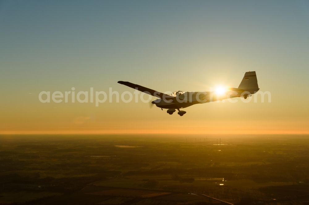 Aerial image Stade - And Motorsegler SF 25 Aircraft in flight while sunset over the airspace in Stade in the state Lower Saxony, Germany