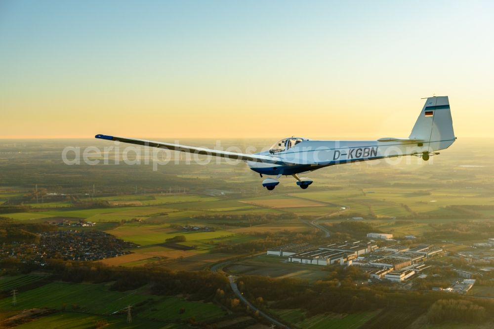 Stade from the bird's eye view: And Motorsegler SF 25 Aircraft in flight while sunset over the airspace in Stade in the state Lower Saxony, Germany