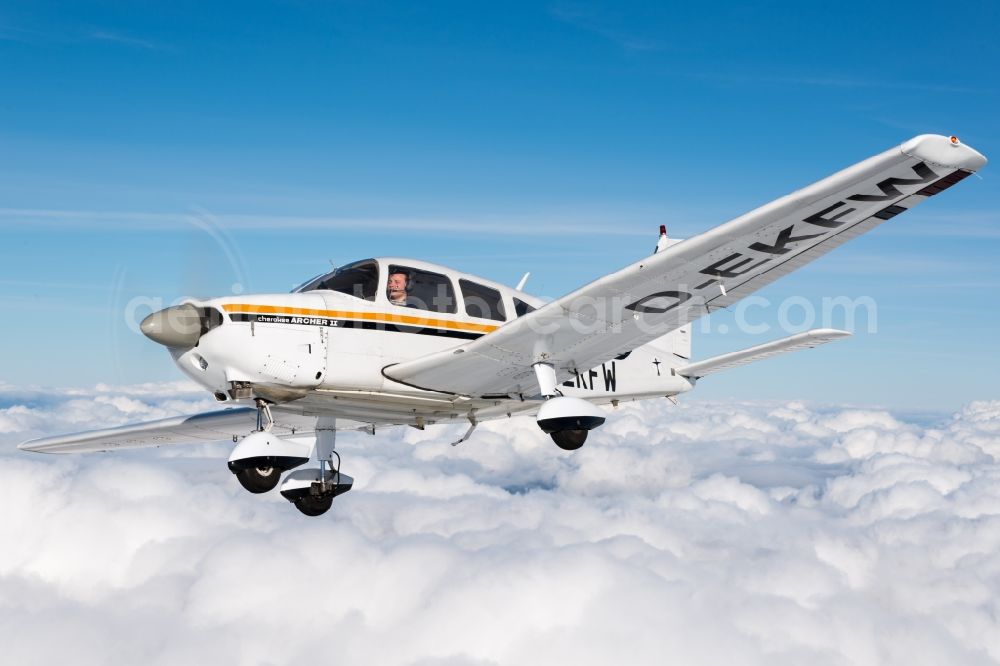 Gnarrenburg from the bird's eye view: Piper Pa28 Archer II D-EKFW Aircraft in flight above the clouds near Gnarrenburg in the state Lower Saxony, Germany. The Piper PA-28 Cherokee is a single-engine, four-seater light aircraft from the US aircraft manufacturer Piper Aircraft Corporation