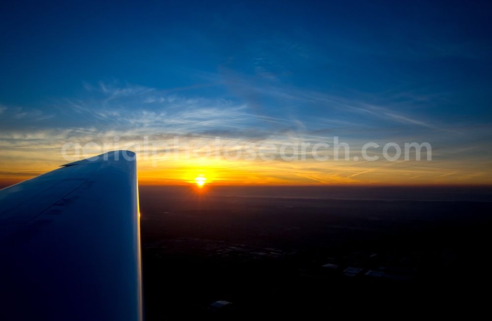 Dortmund from the bird's eye view: Wing a motor glider on the sunset-horizon Aircraft in flight over the airspace in Dortmund in the state North Rhine-Westphalia