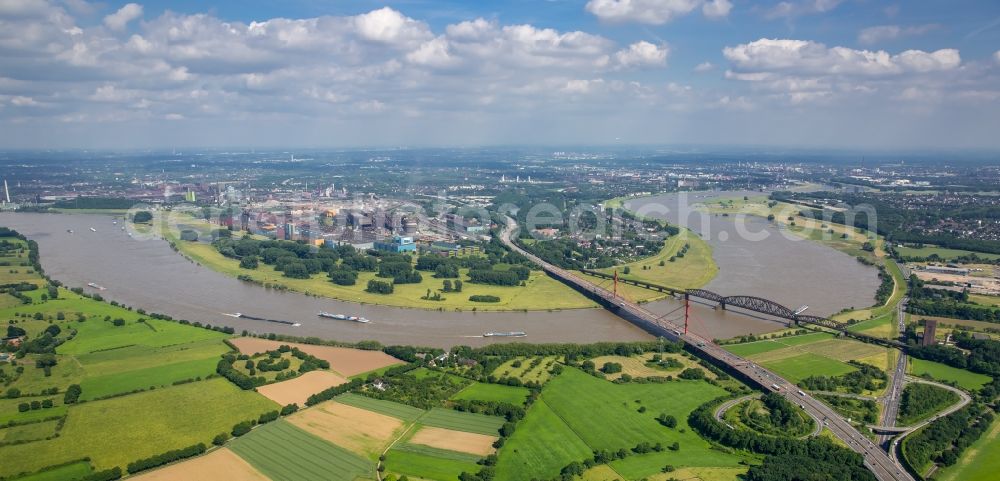 Duisburg from the bird's eye view: River - bridge construction - A42 highway bridge and railway bridge over the Rhine in Duisburg in North Rhine-Westphalia