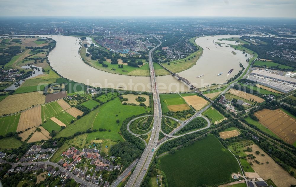 Duisburg from the bird's eye view: River - bridge construction - A42 highway bridge and railway bridge over the Rhine in the district Baerl in Duisburg at Ruhrgebiet in North Rhine-Westphalia