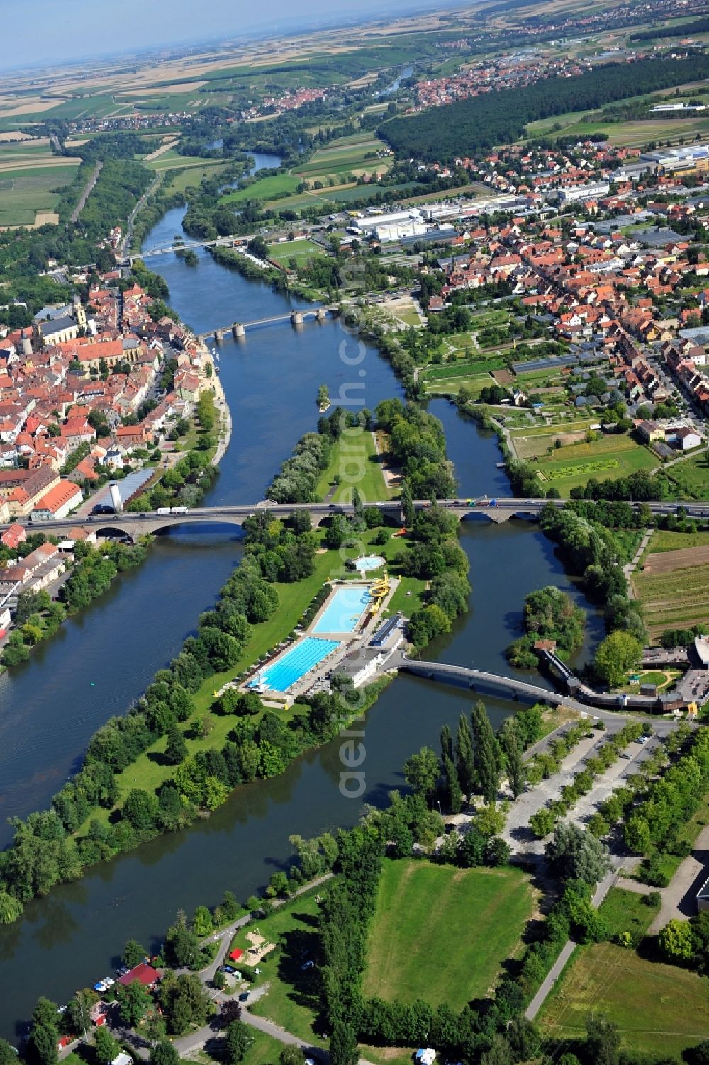 Kitzingen from the bird's eye view: View from south along the Main river with the Konrad-Adenauer-Bridge and the open-air bath on the Mondsee Island, Pipins Bridge, Old Main Bridge and the North Bridge in Kitzingen in the state Bavaria