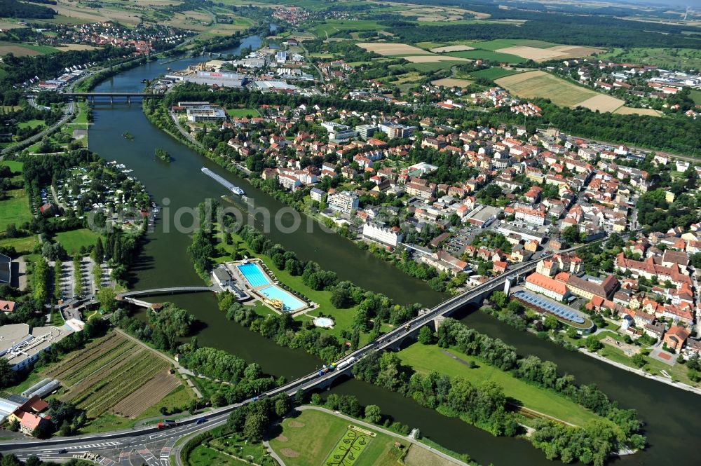 Kitzingen from the bird's eye view: View from northeast along the Main river with the Konrad-Adenauer-Bridge and the open-air bath on the Mondsee Island, the South Bridge and the lock Kitzingen in the state Bavaria