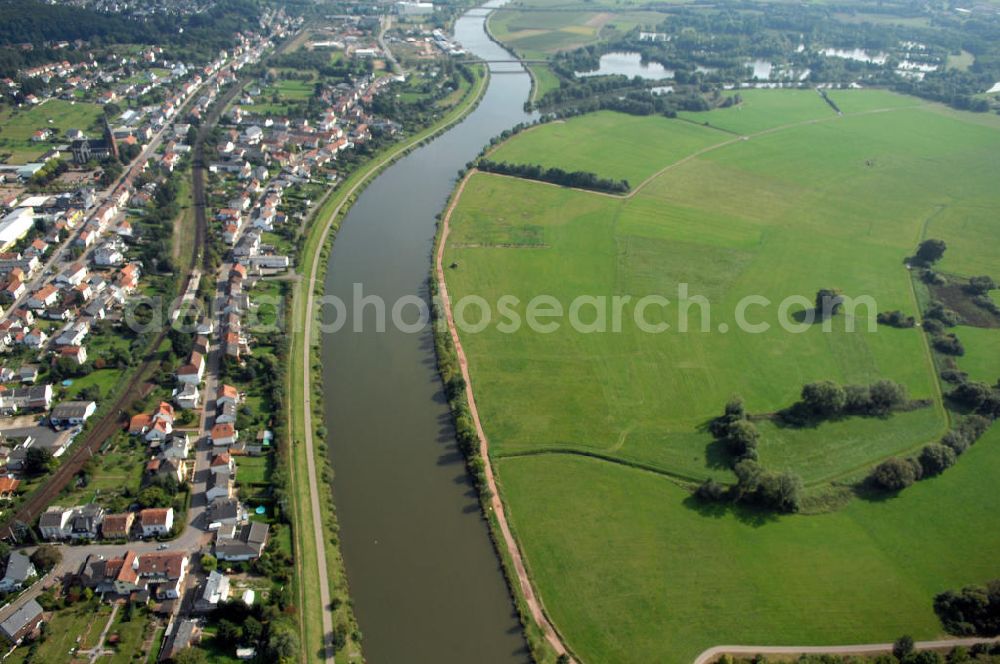 Aerial photograph Besseringen Stadt Merzig - Blick aus Nordwest auf den Flussverlauf der Saar. Auf der linken Uferseite befindet sich die Stadt Besseringen hinter dem Hochwasserschutzdamm und auf der rechten Uferseite Die Aue mit verschiedenen Gräben und Grünland bei Schwemlingen.