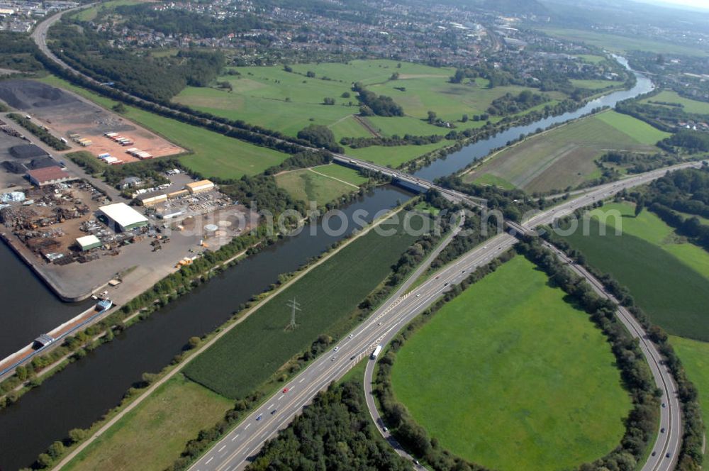 Aerial photograph Saarlouis - Blick aus Westen entlang der Saar in Saarlouis-Roden im Saarland. Am linken Saarufer erstreckt sich die Autobahn 620 mit dem Autobahn-Dreieck Saarlouis. Am rechten Ufer erstreckt sich die BS Baustoff-Sortimenter GmbH. View from west along the Saar river.