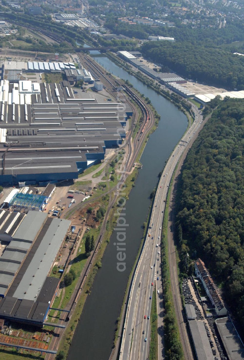 Saarbrücken from above - Blick aus Westen entlang der Saar in Saarbrücken-Burbach im Saarland. Am linken Saarufer erstreckt sich die Autobahn 620 und das Messegelände Schanzenberg. Am rechten Ufer erstreckt sich das Stahlwerk Burbach der Saarstahl AG und das Burbach Fachmarktzentrum Westpark auf dem Gelände der Saarterassen. View from west along the Saar river.