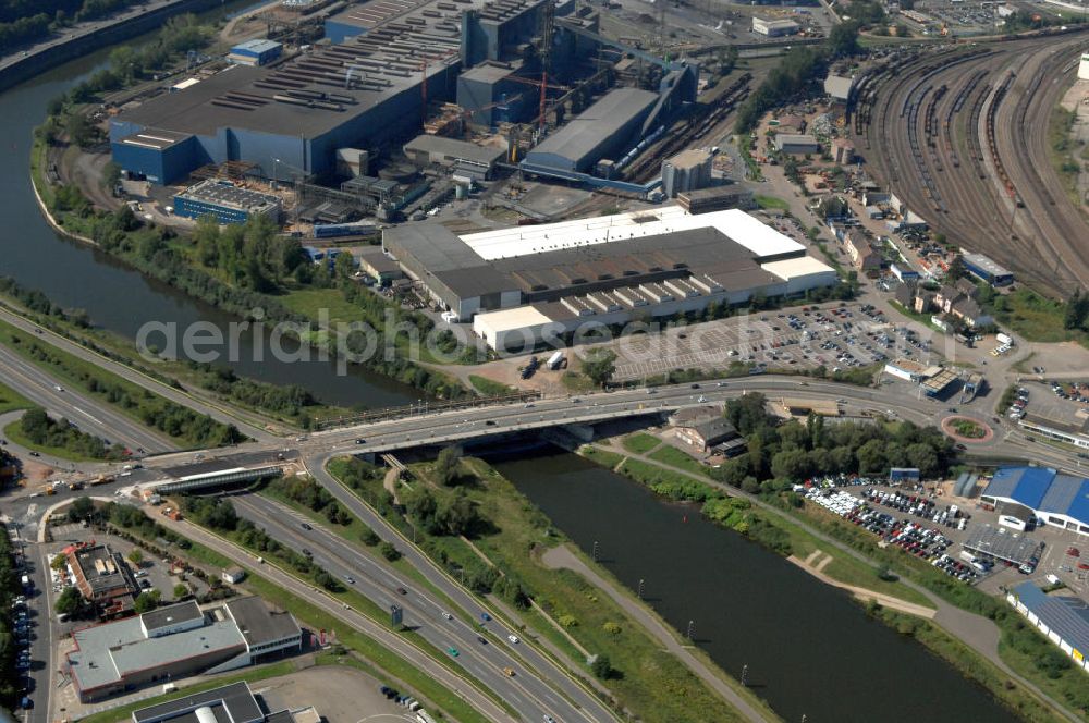 Völklingen from the bird's eye view: Blick aus Nordosten entlang der Saar mit der Karolinger Brücke in Völklingen im Saarland. Am linken Saarufer erstreckt sich sich die Autobahn 620 mit der Ausfahrt Völklingen im Stadtteil Fürstenhausen. Am rechten Ufer erstreckt sich in der Stadtmitte ein Autohaus und ein Werkstattgebäude des Stahlwerk Völklingen der Saarstahl AG . View from east along the Saar river.