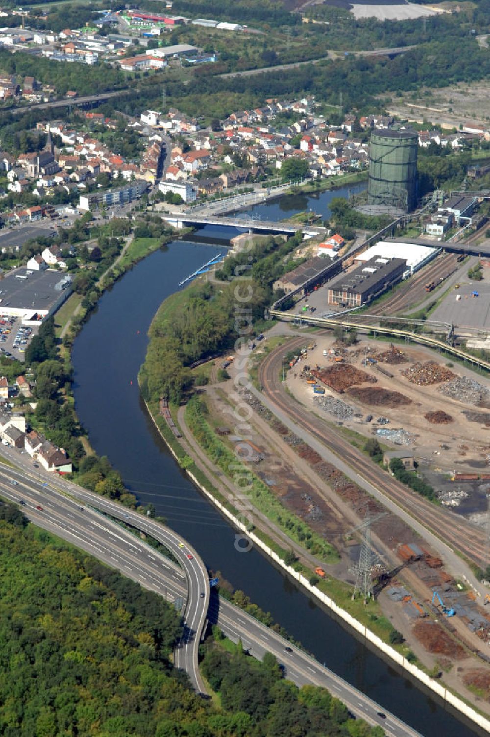 Völklingen from the bird's eye view: Blick aus Südosten entlang der Saar mit der Brücke Rathausstraße in Völklingen im Saarland. Am linken Saarufer erstreckt sich die Autobahn 620 im Stadtteil Wehrden. Am rechten Ufer erstreckt sich in der Stadtmitte das Stahlwerk Völklingen der Saarstahl AG und das UNESCO Weltkulturerbe Völklinger Hütte. View from southeast along the Saar river.