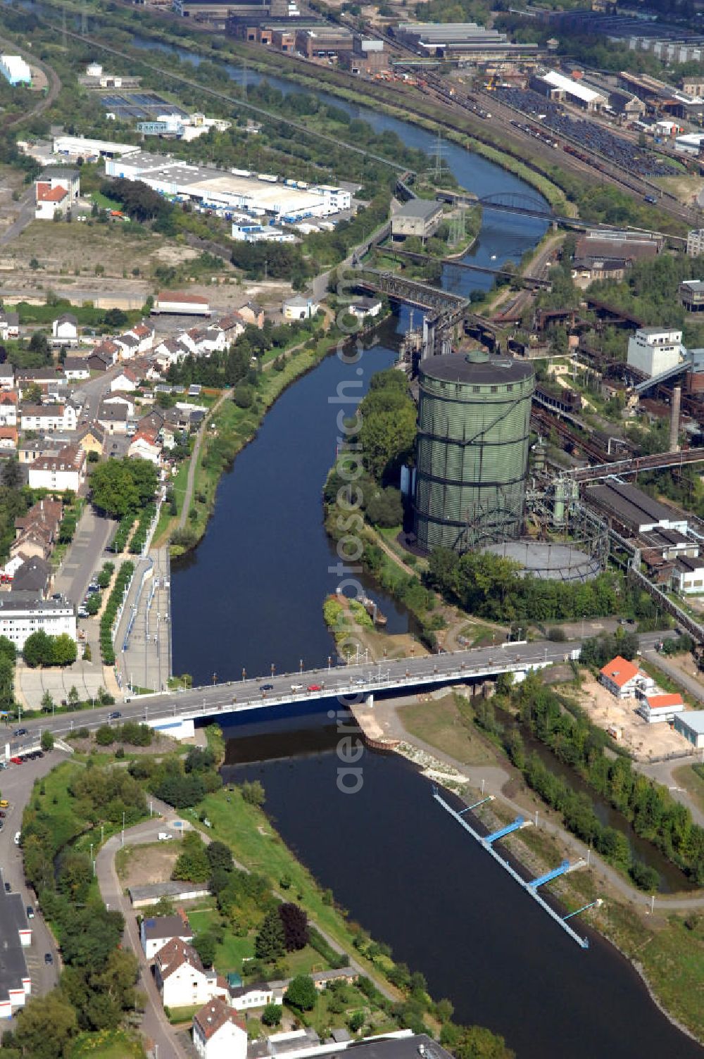 Aerial photograph Völklingen - Blick aus Süden entlang der Saar mit der Brücke Rathausstraße in Völklingen im Saarland. Am linken Saarufer erstreckt sich der Stadtteil Wehrden. Am rechten Ufer erstreckt sich in der Stadtmitte das UNESCO Weltkulturerbe Völklinger Hütte. View from south along the Saar river.