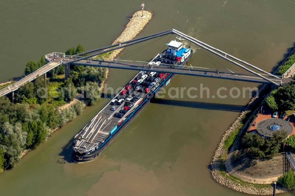 Düsseldorf from the bird's eye view: Cargo ship drinving into the Duesseldorfer Wirtschaftshafen unter a pedestrian bridge in Duesseldorf in the state North Rhine-Westphalia